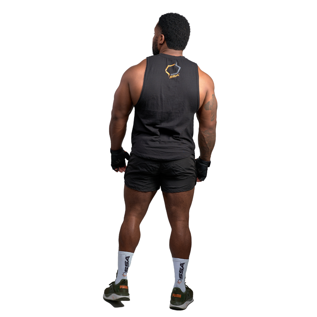 A man wearing a black sleeveless tank top and black shorts